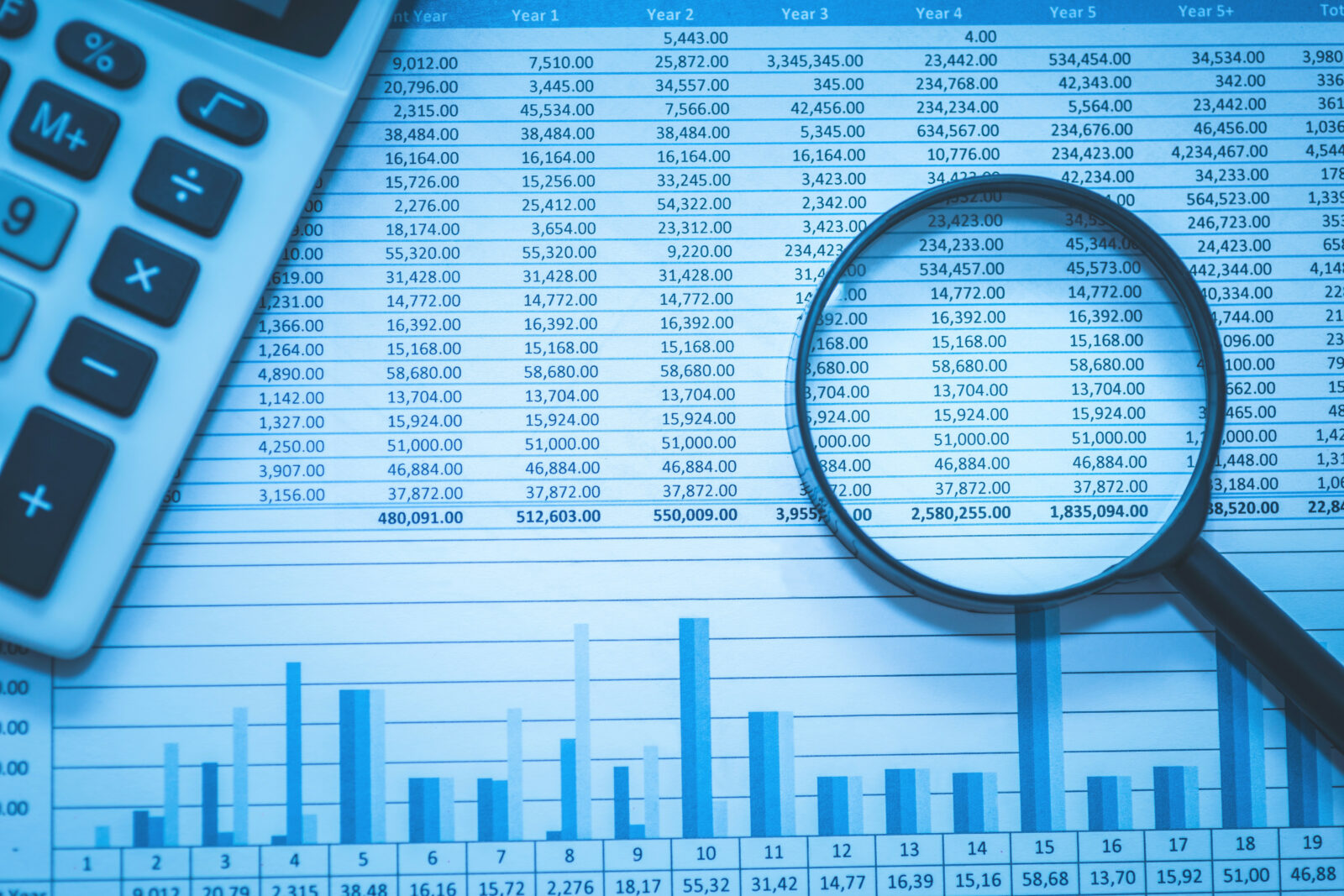 Image of a spreadsheet, calculator and magnifying glass